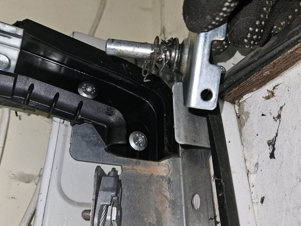 Cable de acero y soporte inferior en el ángulo de una puerta seccional